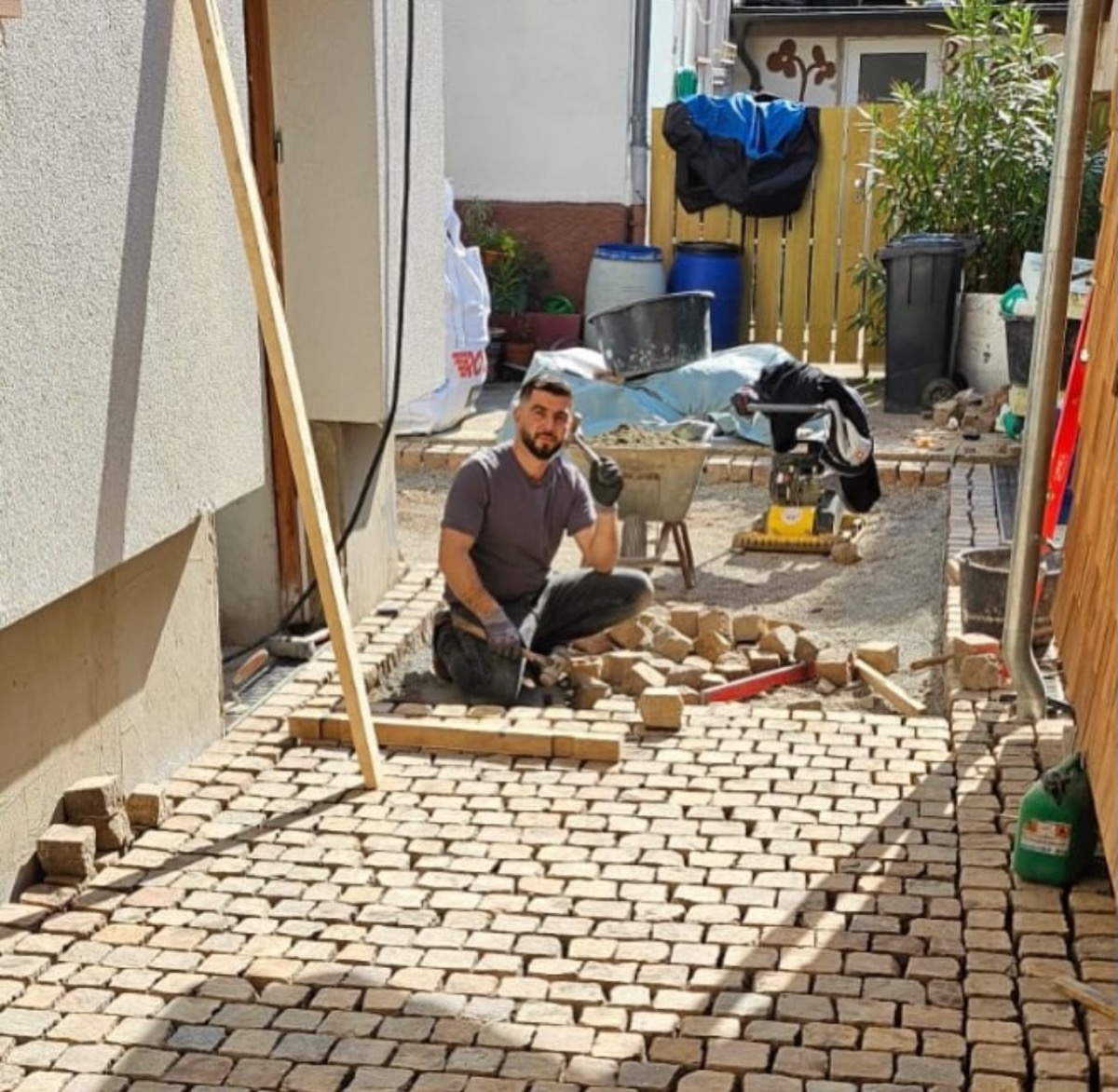 Pflasterarbeiten: Verlegen von Natursteinpflaster in einem Hof